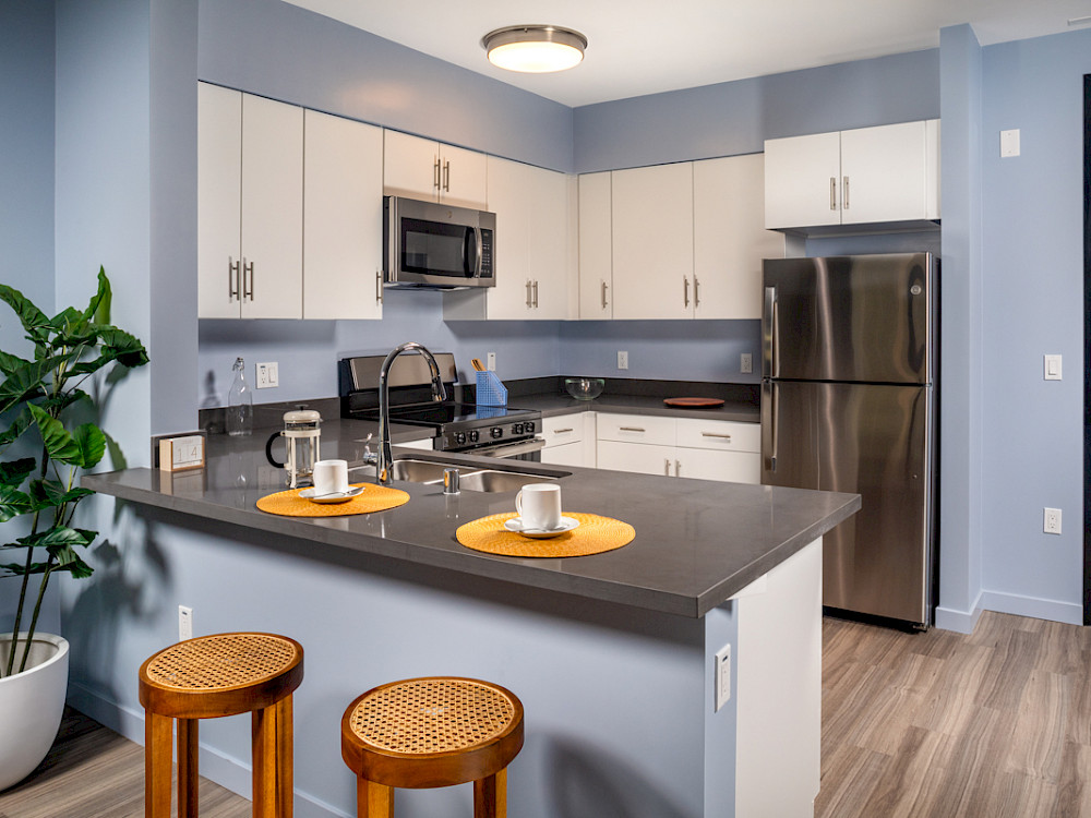 Apartments for Rent Westlake, CA - Wilco Apartments Modern Kitchen with Breakfast Bar, Sleek Stainless Steel Appliances, and White Cabinetry