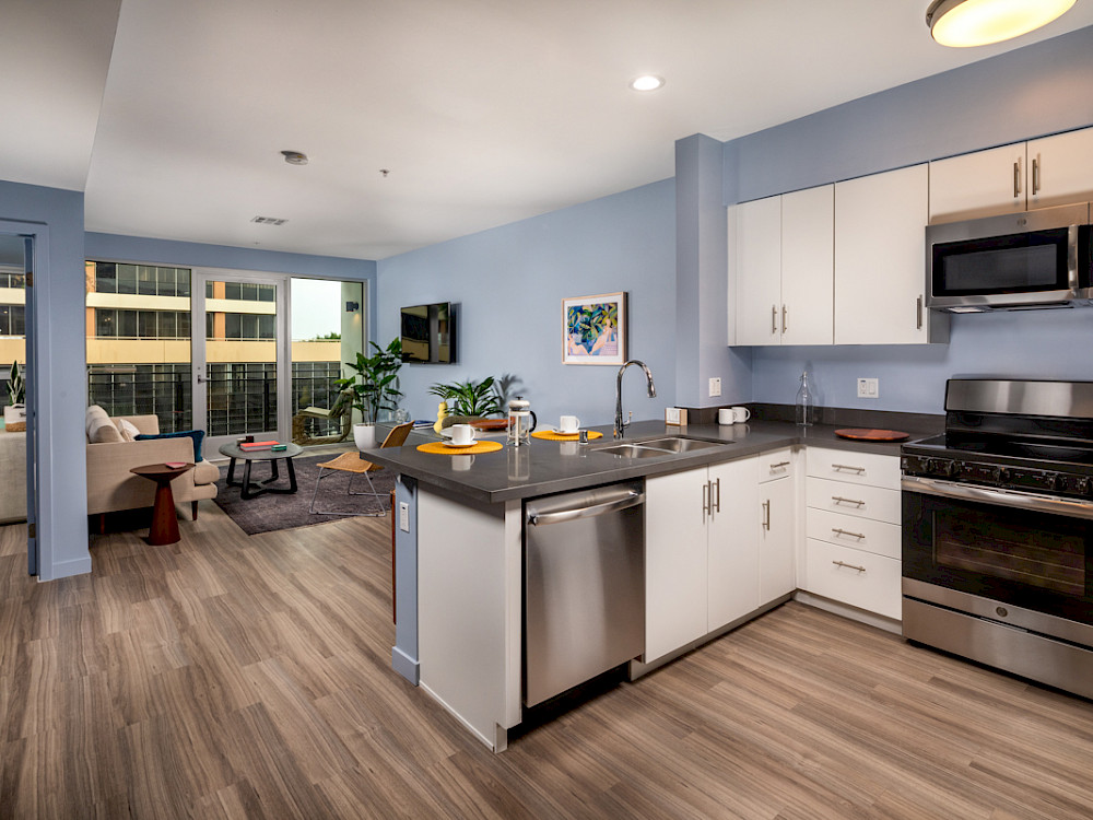 Apartments for Rent in Westlake, CA - Wilco Kitchen with Breakfast Bar, Stainless Steel GE Appliances, Quartz Countertops, Wood-Style Plank Flooring, and Matte White Cabinetry